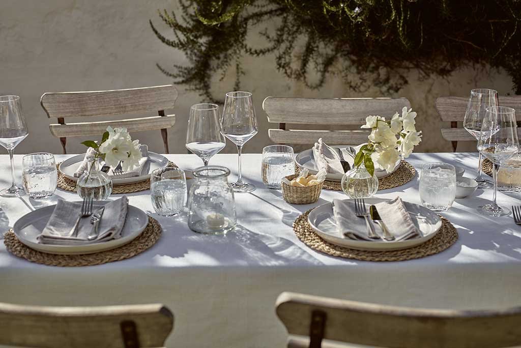 tavola apparecchiata lino sottopiatti rattan calici