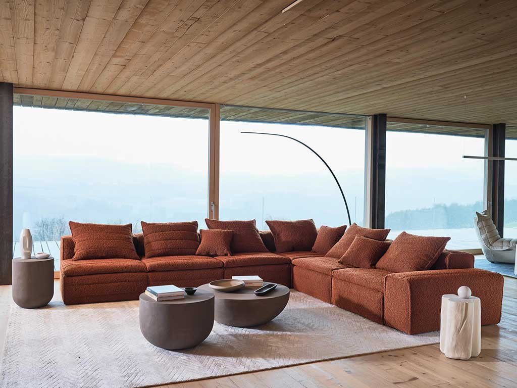 divano angolare colore mattone rifinito trapuntato