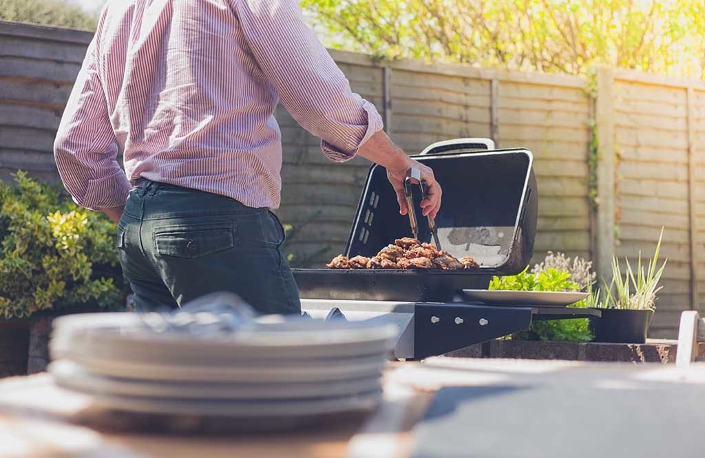 uomo che cuoce barbecue carne