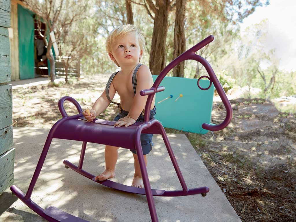 bambino appoggiato cavallo a dondolo