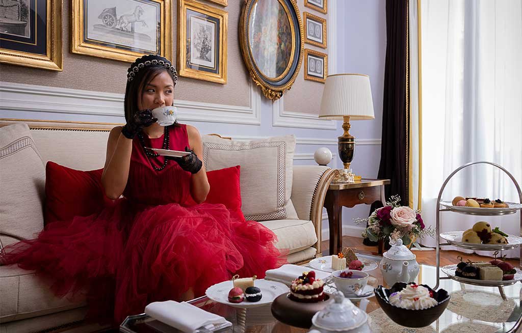 ragazza vestita rosso prende the tavolo apparecchiato scones