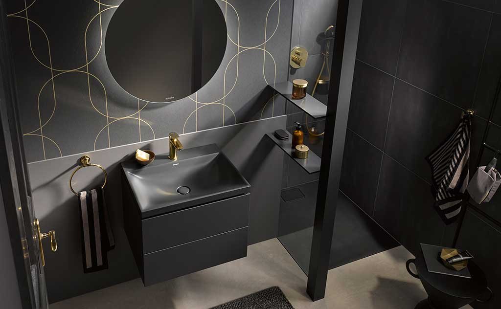 arredo bagno grigio scuro con rubinetto oro